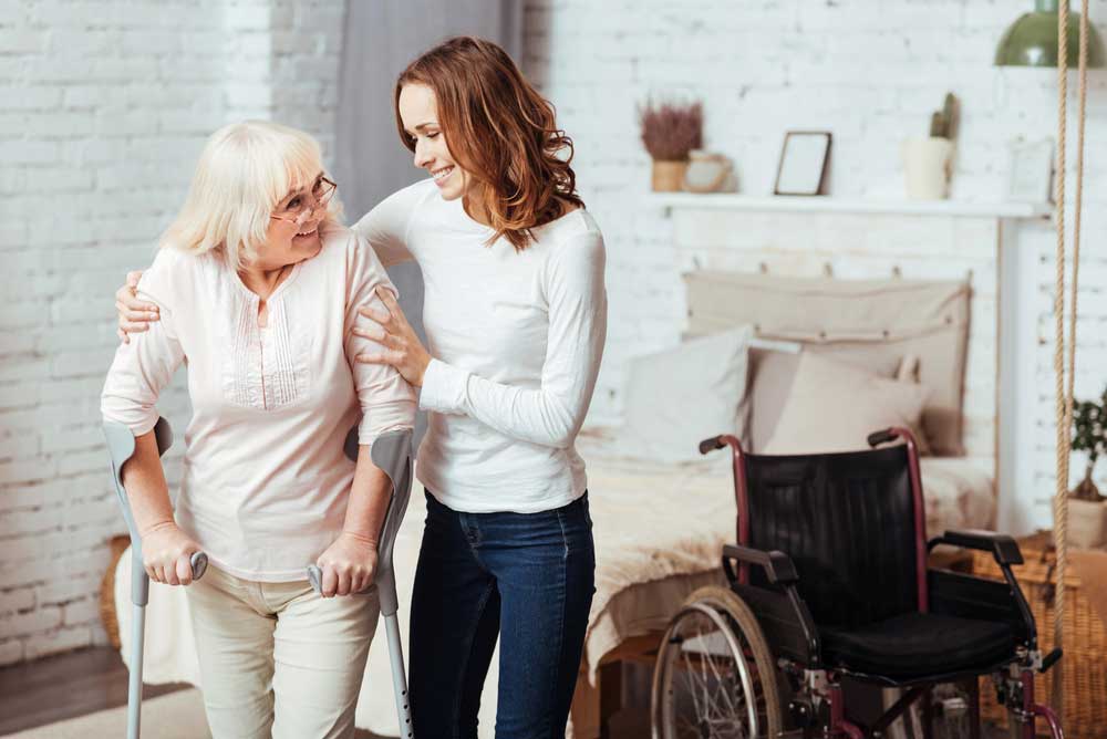 Caring Women Helping Her Grandmother To Walk — Disability Services in Weston, NSW