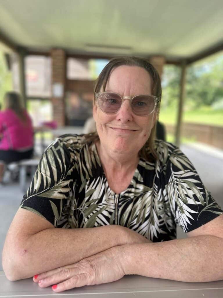 A Smiling Person in an Undercover Area — Gleam Support Services Pty Ltd in Weston, NSW