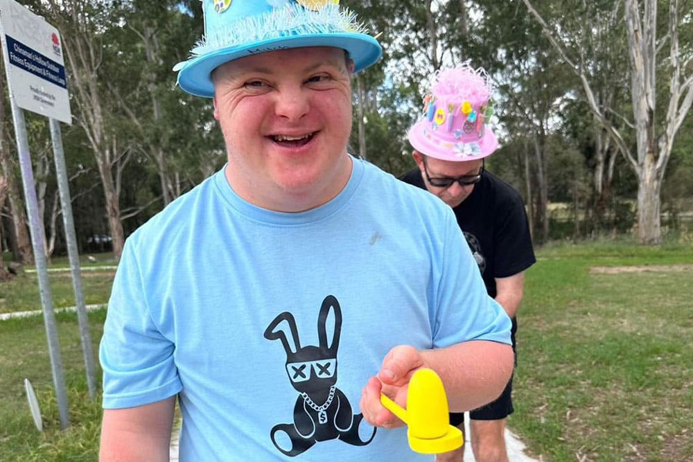 A Person Holding a Yellow Spoon and Egg — Gleam Support Services Pty Ltd in Weston, NSW