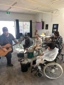 Man Playing a Guitar to A Group of People