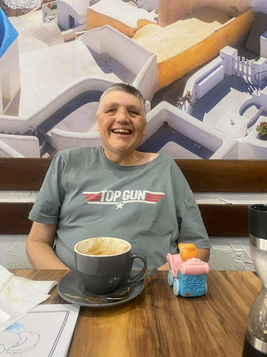 A Person Smiling With A Cup Of Coffee