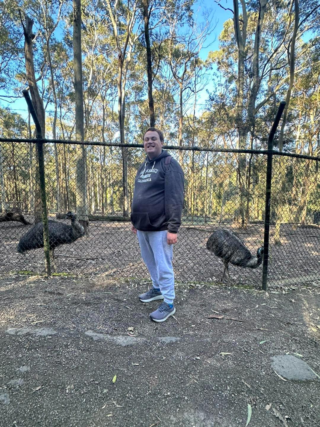 Man Smiling With Two Birds At The Back