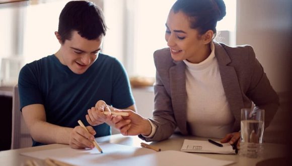 A Woman And A Young Man Drawing Together — Gleam Support Services Pty Ltd in Weston, NSW