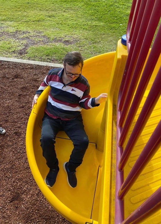 Man Playing In Slide — Disability Services in Weston, NSW