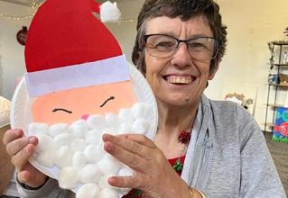 Woman Holding Santa Claus Art — Disability Services in Weston, NSW