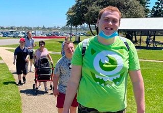 People Smiling While Walking In The Park — Disability Services in Newcastle, NSW
