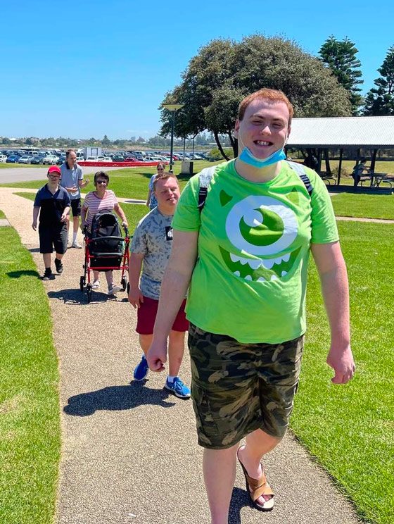 People Smiling While Walking In The Park — Disability Services in Weston, NSW