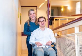 Man In A Wheelchair Smiles Next To A Woman On A Sunny Day Outdoors — Gleam Support Services Pty Ltd in Weston, NSW